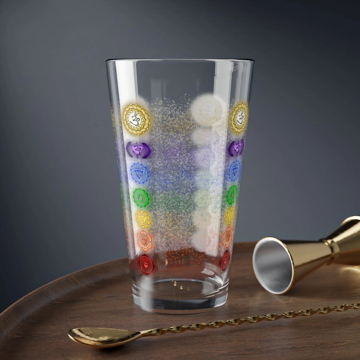 7 Chakra Balancing Glass in a lifestyle setting on a wooden table with bar tools.
