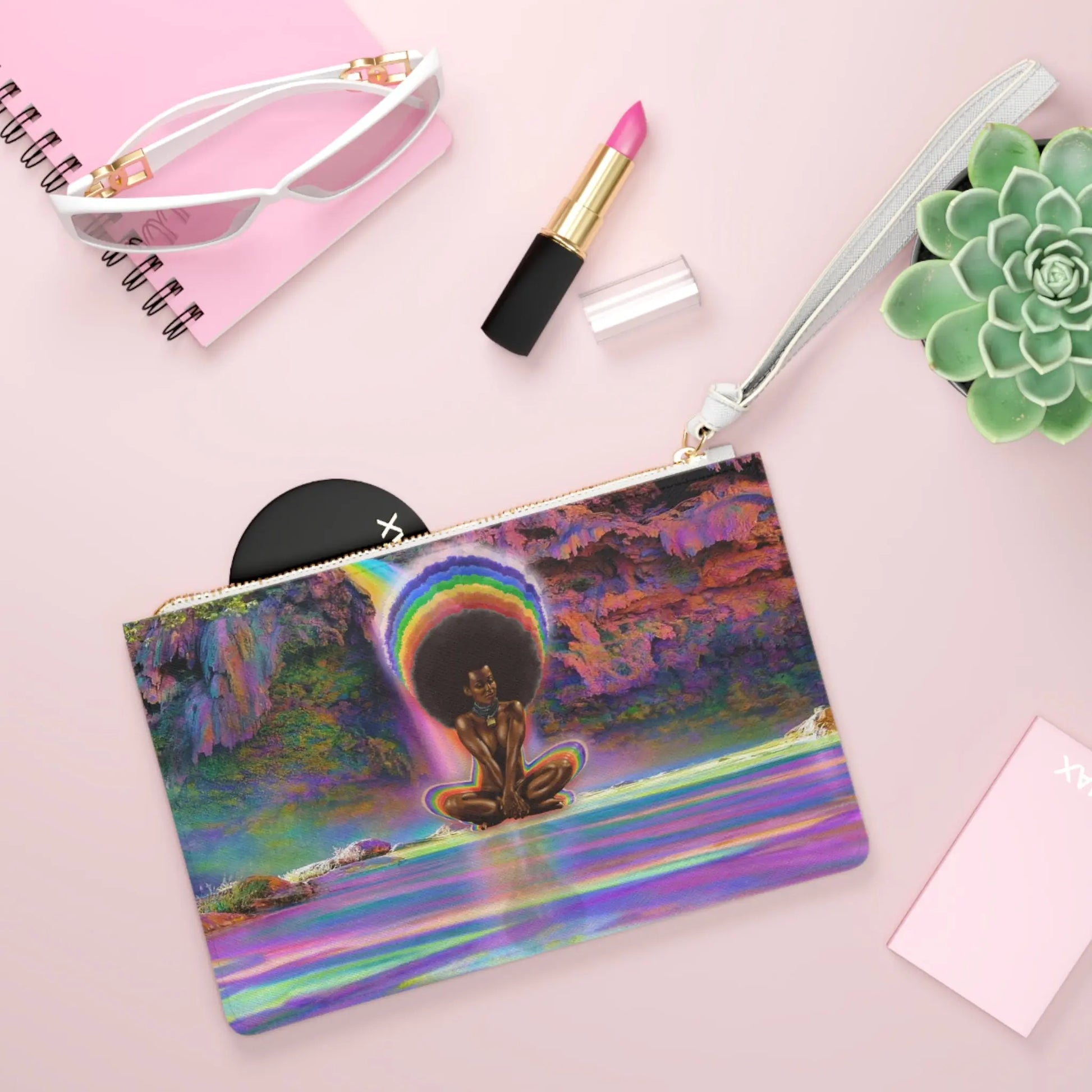 Black Girl Magic Clutch shown in a lifestyle setting with sunglasses and lipstick on a pink background.