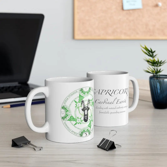 Two Capricorn Zodiac Mugs on a desk, showing both the quote side and the elemental sigil side.