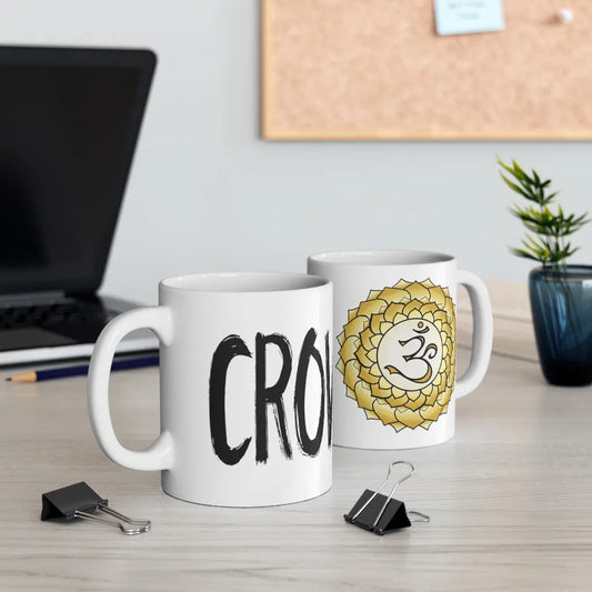 Two Crown Chakra Mugs on a desk, showing both the chakra symbol side and the "CROWN" text side.