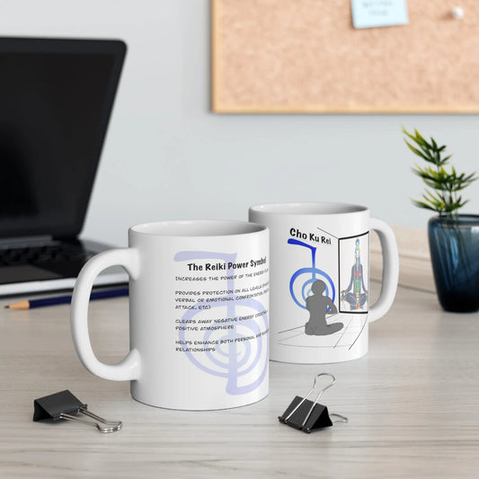 Two Cho Ku Rei Reiki Mugs on a desk with a laptop in the background.