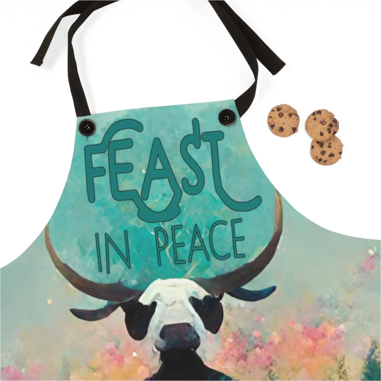 Turquoise 'Feast in Peace' apron with bull skull design, paired with chocolate chip cookies