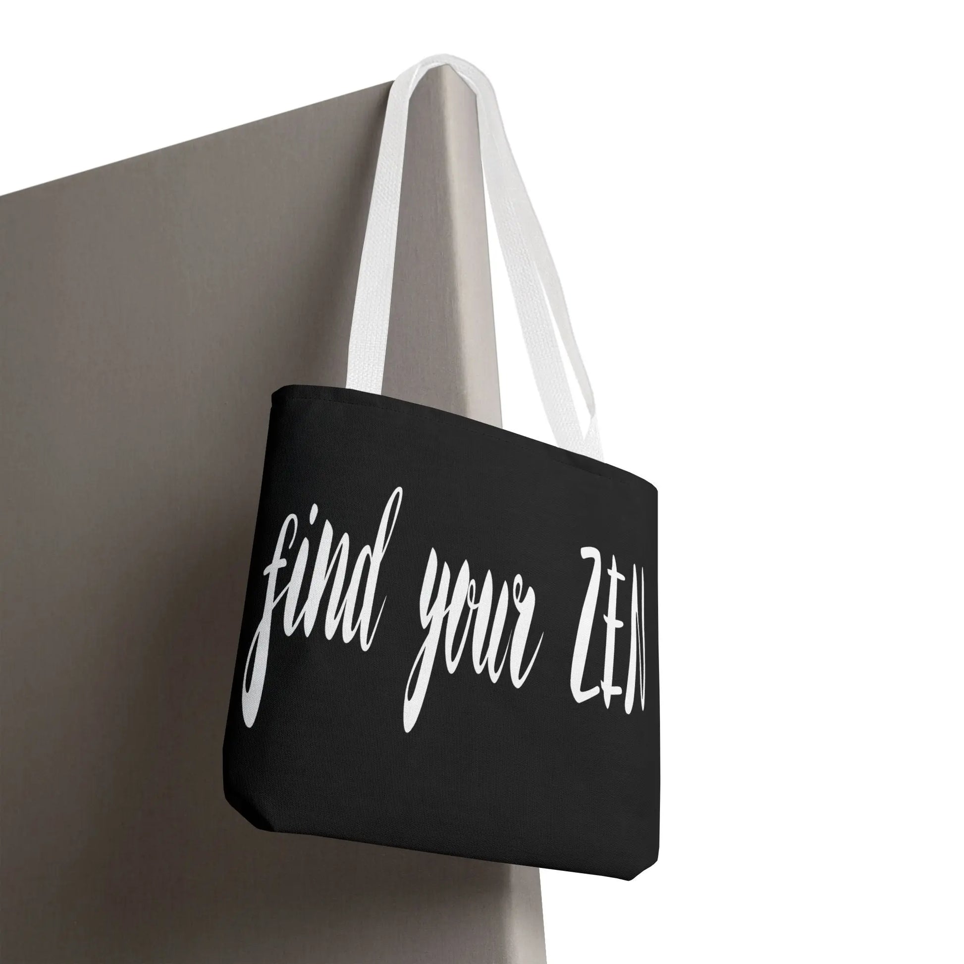 "Find Your Zen" Tote Bag - Plain black canvas back view hanging on a door.