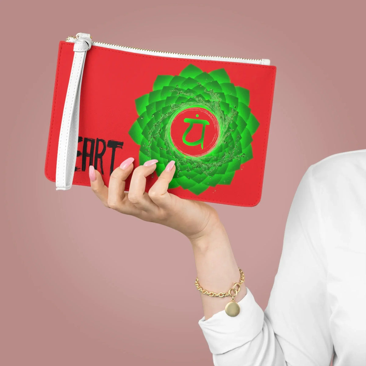 Red pouch with green heart chakra symbol and 'HEART' text, held by hand with pink nails