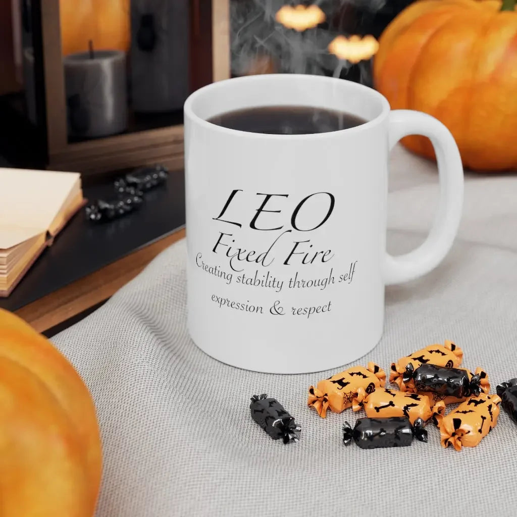 Leo astrology mug with 'Fixed Fire' text, surrounded by Halloween candies and pumpkins, perfect for zodiac lovers.