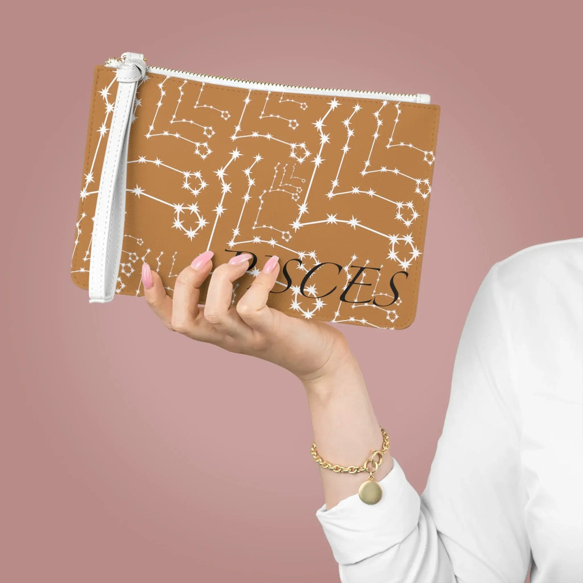 Pisces constellation pouch with star map design, held by hand with pink nails and gold bracelet