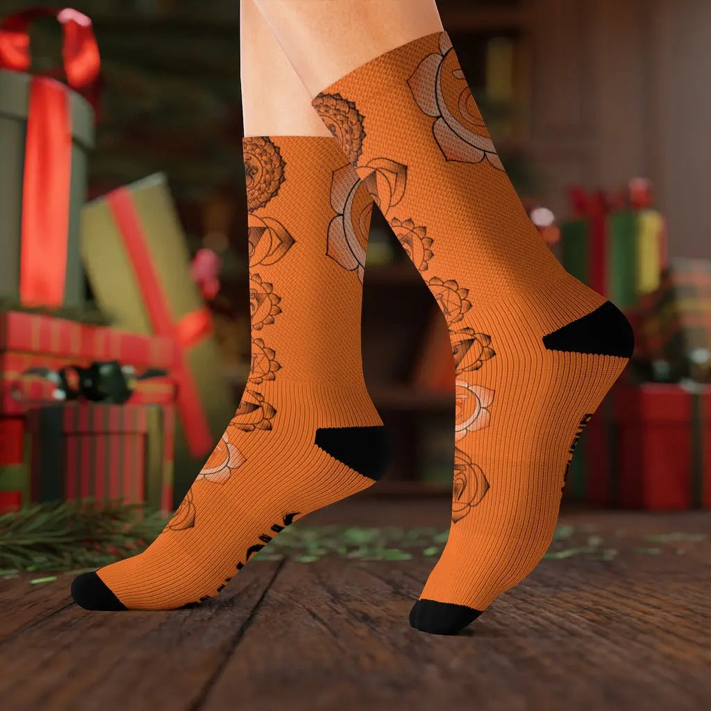 Model (Lifestyle): Model wearing the vibrant orange Sacral Chakra socks in a festive setting with wrapped holiday gifts in the background.