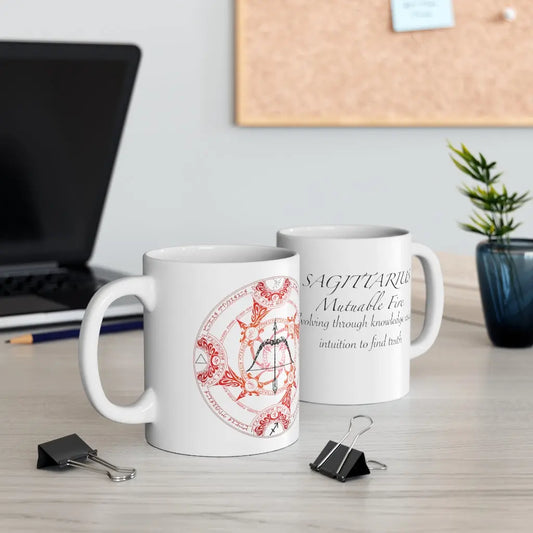 Two Sagittarius Zodiac Mugs on a desk, showing both the quote side and the elemental sigil side.
