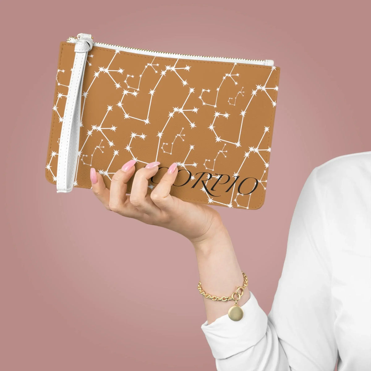 Scorpio constellation pouch with star map design, held by hand with pink nails and gold bracelet