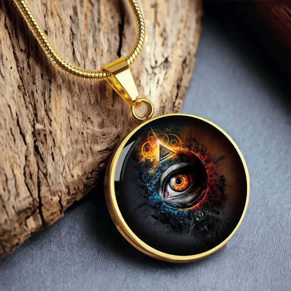Gold Eye of Consciousness Necklace laying on a piece of wood.