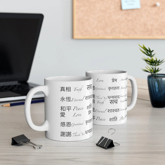 Two Power of Words Mugs on a desk, showing the multilingual text design.
