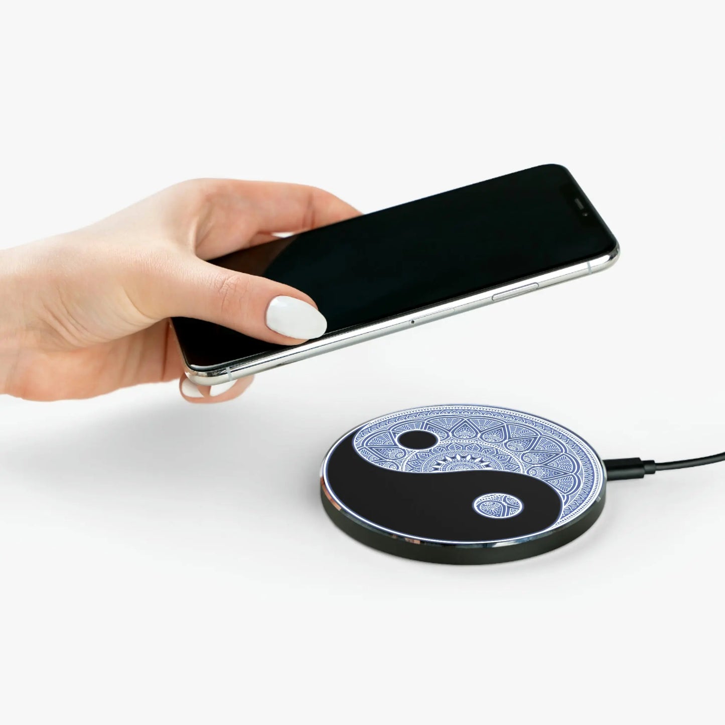 Person placing a phone onto the "Yin Yang Mandala" Wireless Charger.