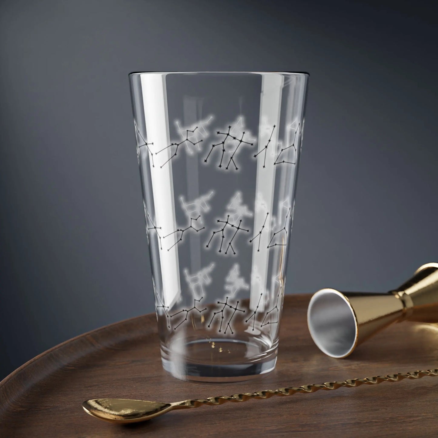 Zodiac Constellation Glass in a lifestyle setting on a wooden table with bar tools.