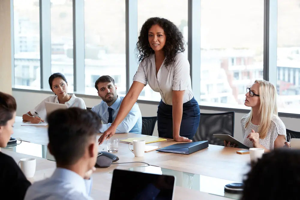 Business team in meeting with leader presenting at conference table in modern office