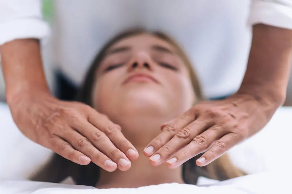 Reiki energy healing session with hands hovering over relaxed recipient for chakra balance and wellness