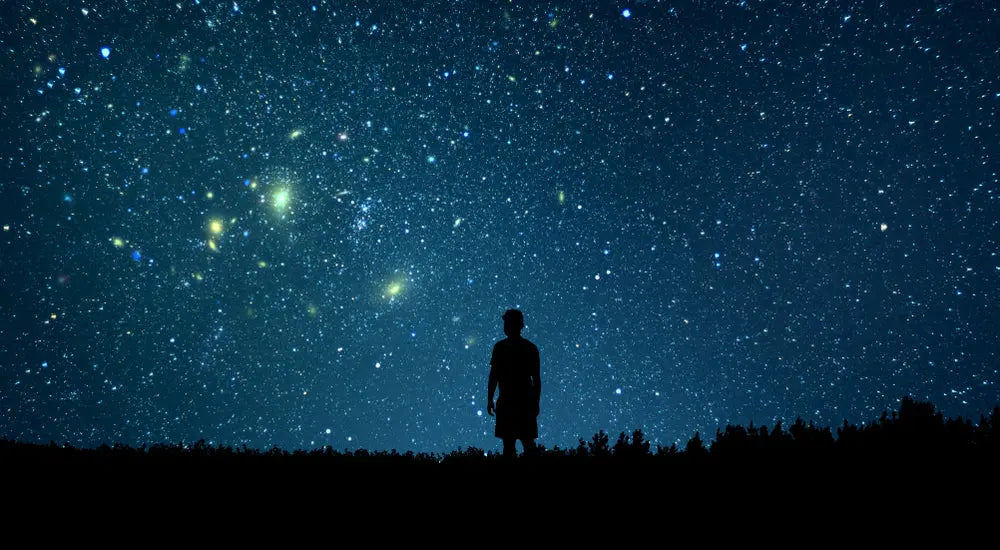 Silhouette of person gazing at starry night sky, cosmic energy, astrology, chakra alignment