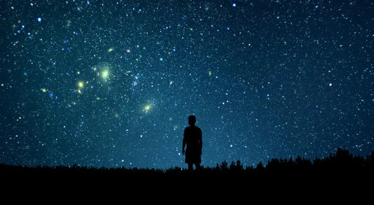 Silhouette of person gazing at starry night sky, cosmic energy, astrology, chakra alignment